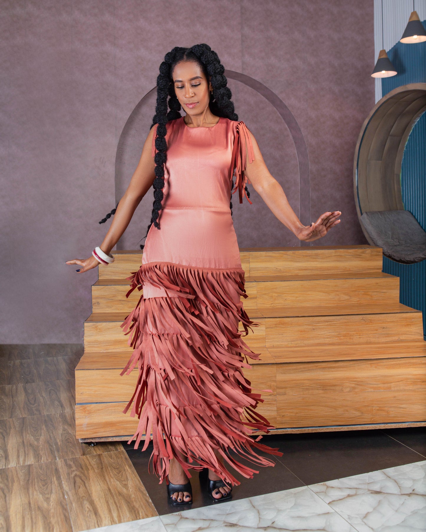 Woman wearing a stylish pink satin maxi dress with fringes