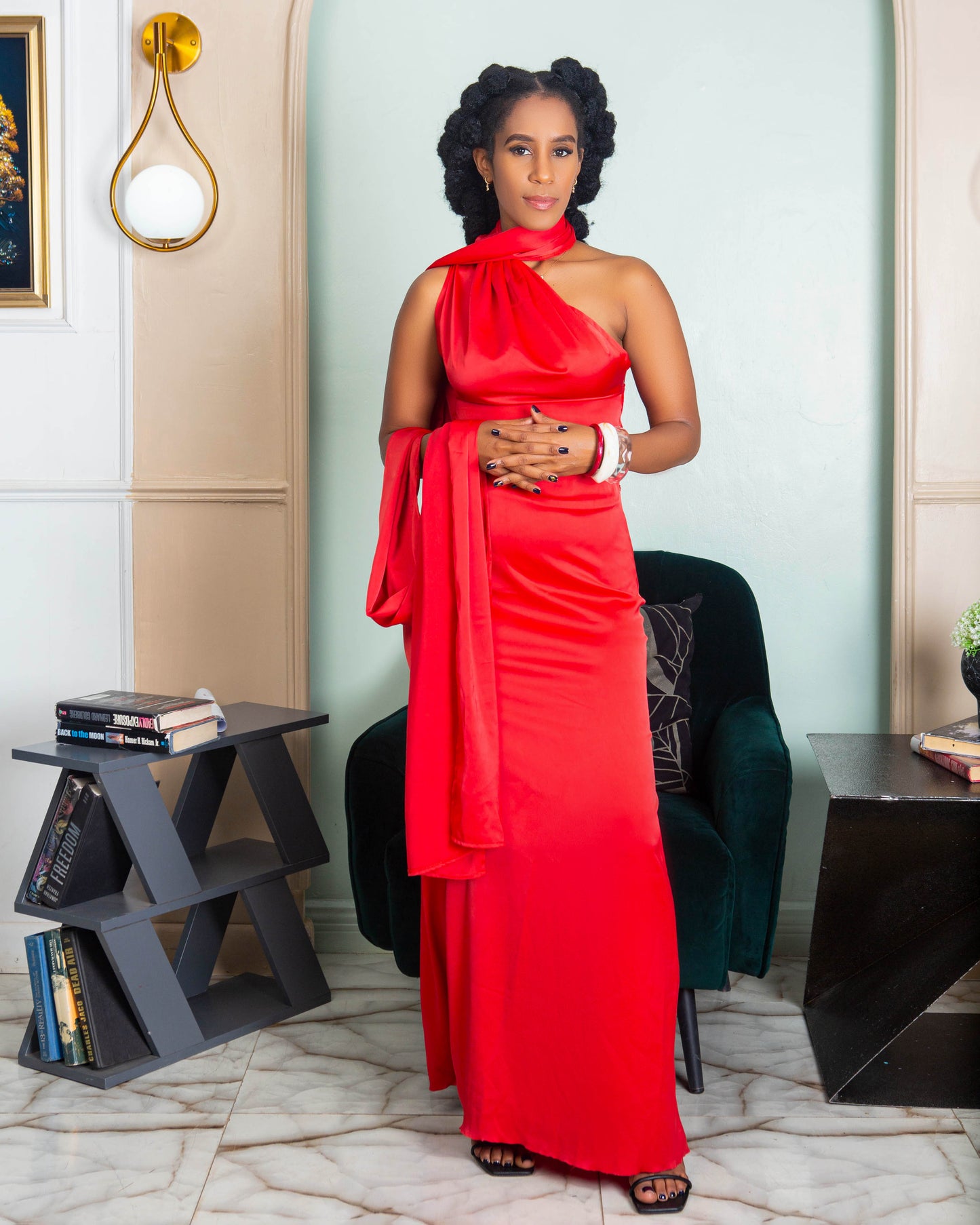 A beautiful woman wearing a red halter neck maxi dress with open back