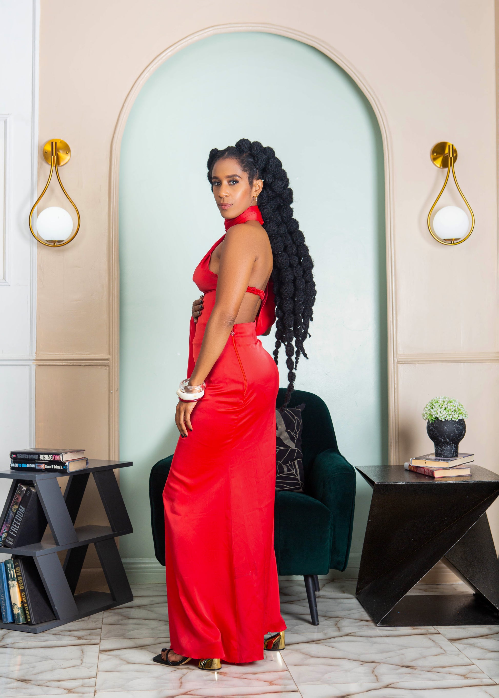 A beautiful woman wearing a red halter neck maxi dress with open back