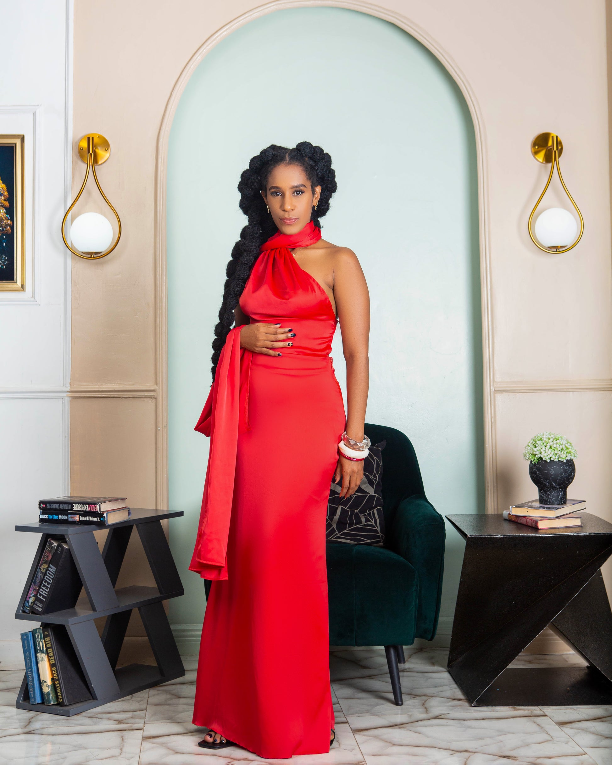 A beautiful woman wearing a red halter neck maxi dress with open back