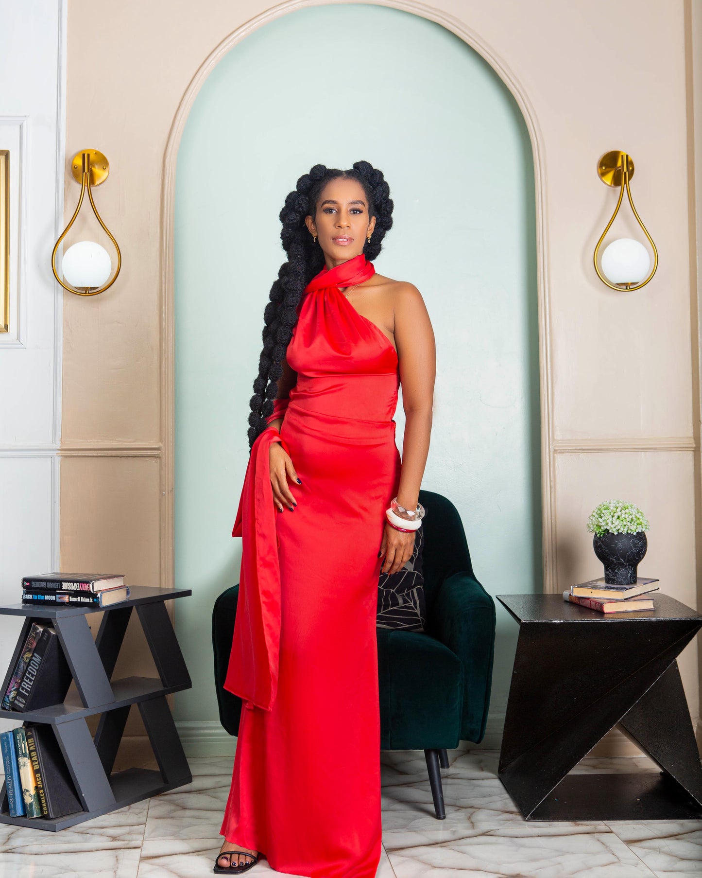 A beautiful woman wearing a red halter neck maxi dress with open back