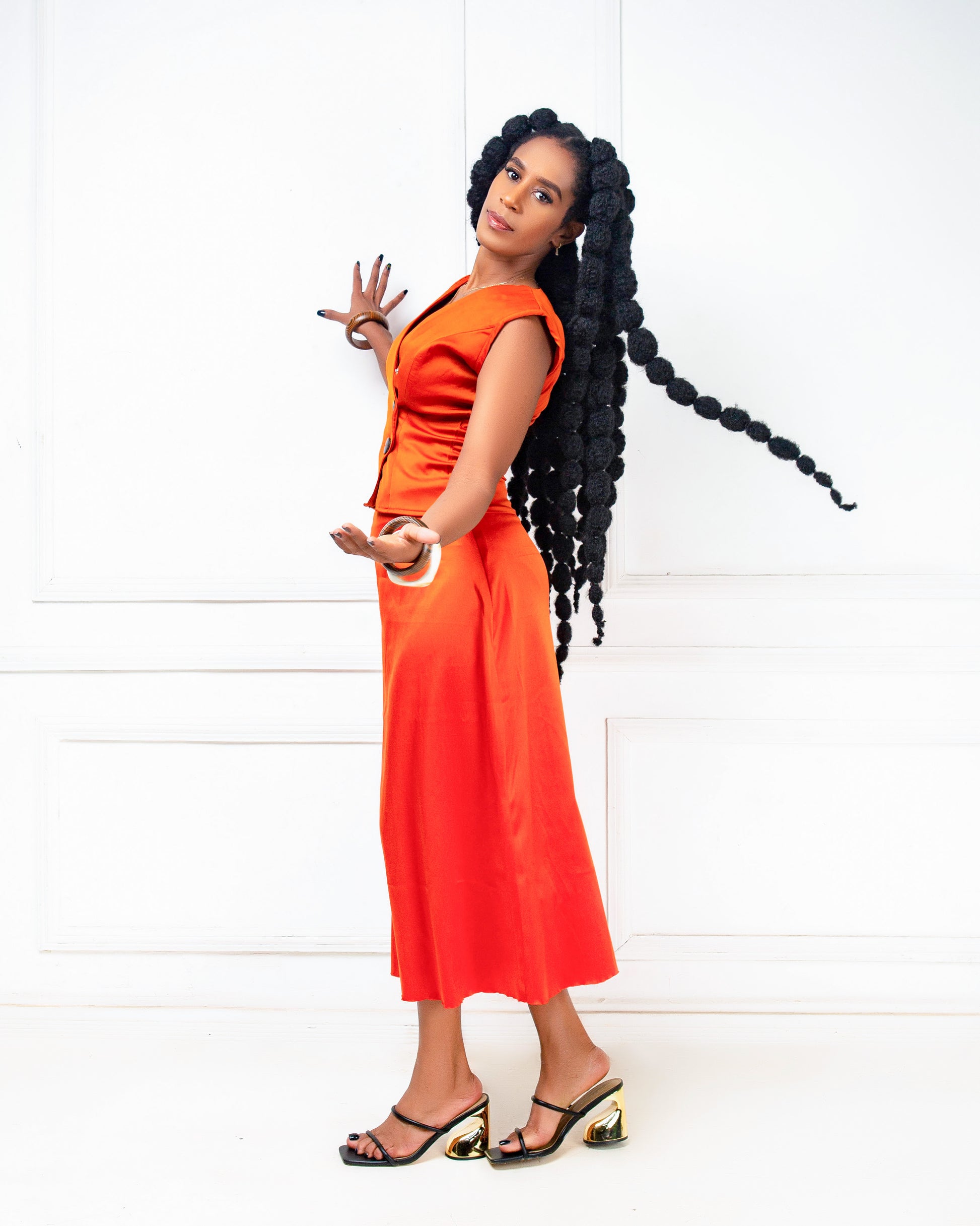 Woman wearing an orange two -piece skirt set