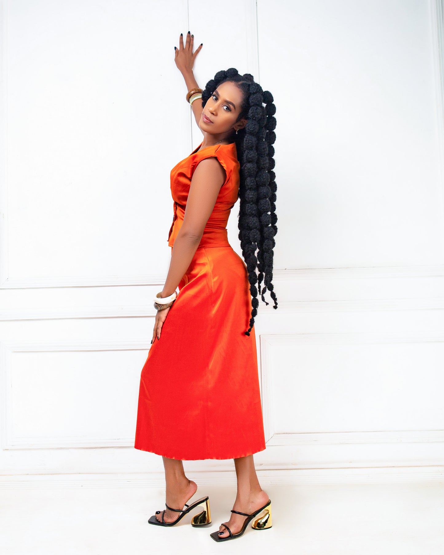 Woman wearing an orange two -piece skirt set